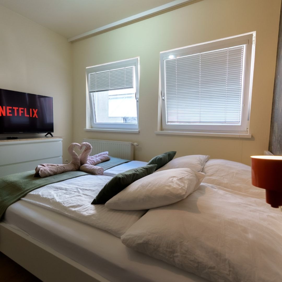 Helles Schlafzimmer mit Smart-TV und liebevollen Details